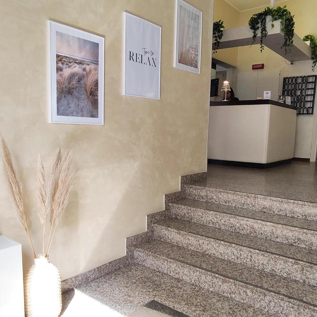 - un hall avec des escaliers et des affiches sur le mur dans l'établissement Hotel Galassia, à Rimini