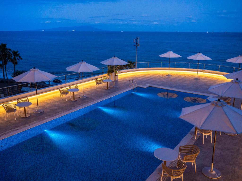 - une piscine avec parasols et chaises et l'océan dans l'établissement Atagawa Ocean Resort, à Higashiizu 37 autres photos