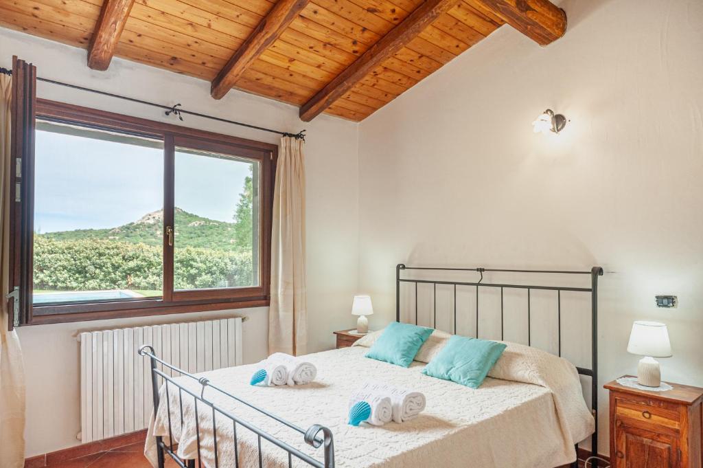 une chambre avec un lit avec une grande fenêtre dans l'établissement [VILLA CON PISCINA] NELLE COLLINE DELLA GALLURA, à Arzachena