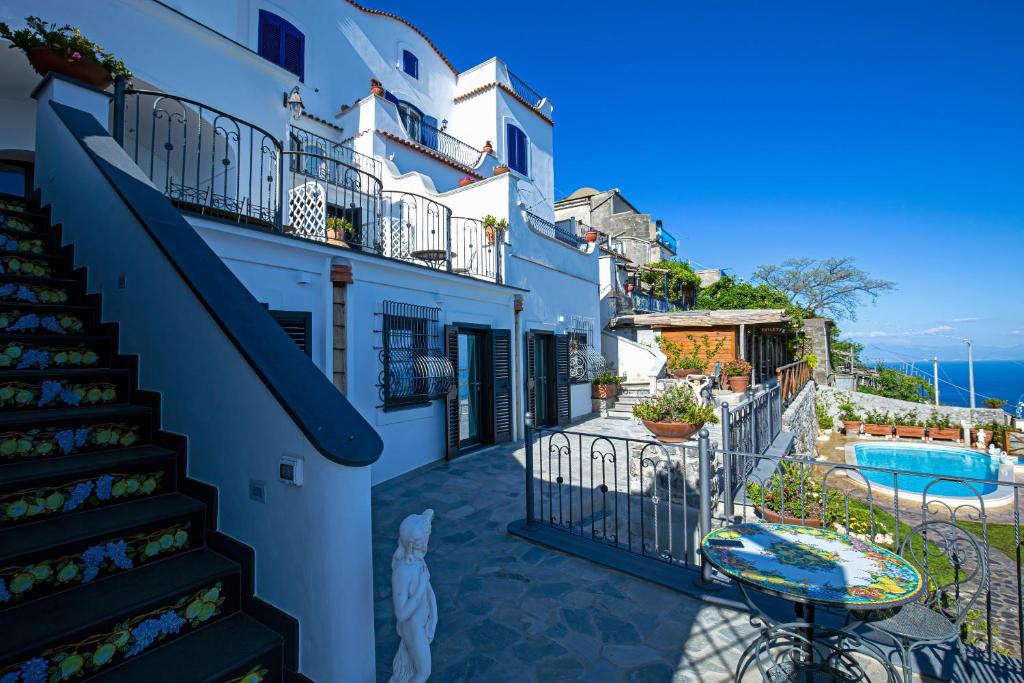 une maison blanche avec un escalier et une piscine dans l'établissement Villa Primavera, à Furore