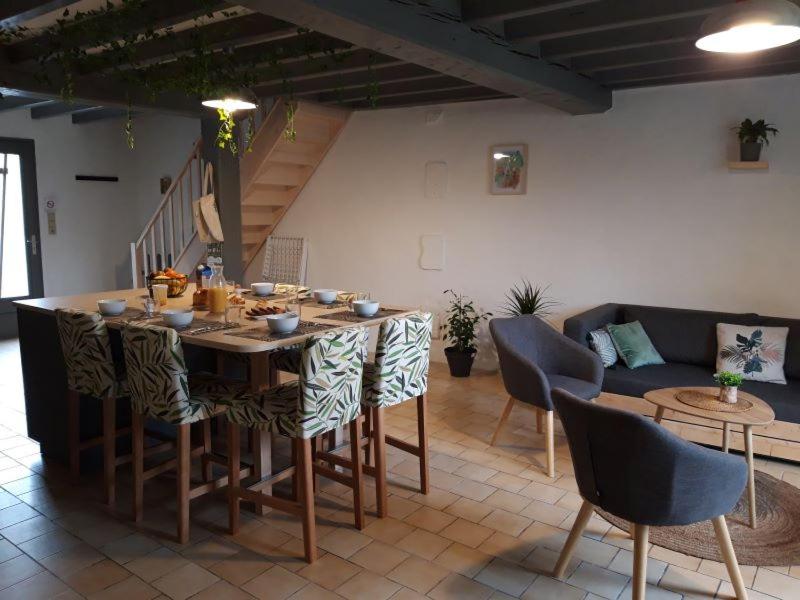 un salon avec une table, des chaises et un canapé dans l'établissement Camping des Tourbières - Gîtes, à Vendoire