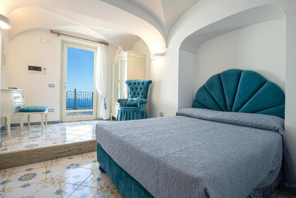 - une chambre avec un lit et deux chaises bleues dans l'établissement Villa Primavera, à Furore 51 autres photos