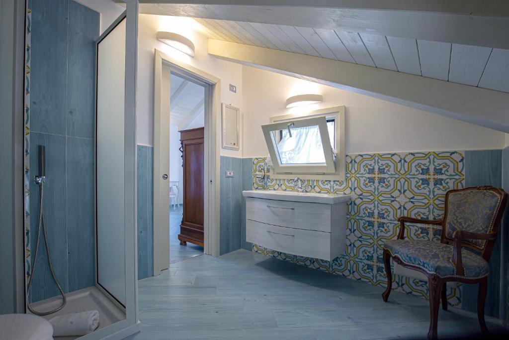 La salle de bains est pourvue d'un lavabo, d'une chaise et d'un miroir. dans l'établissement Villa Primavera, à Furore