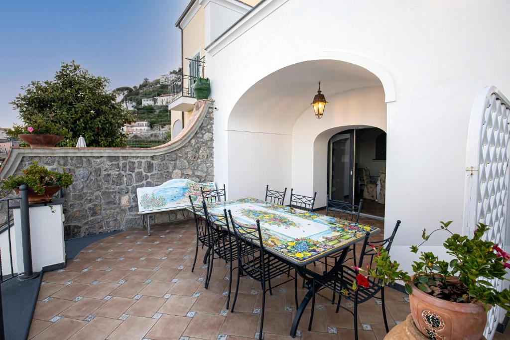 un patio avec une table et des chaises sur un balcon dans l'établissement Villa Primavera, à Furore