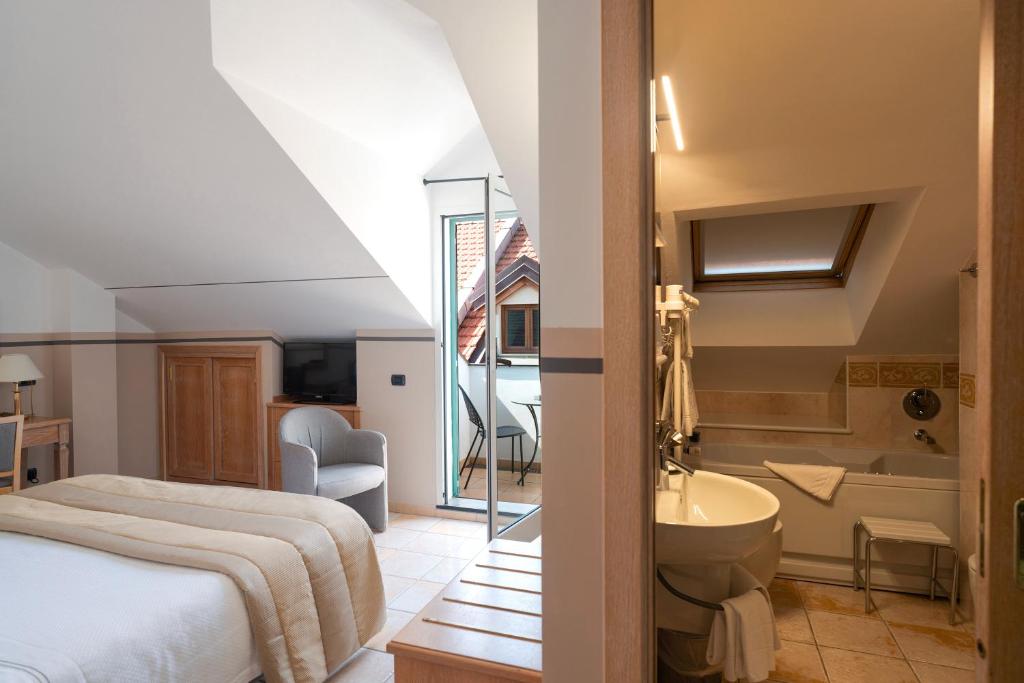 une chambre avec un lit et une salle de bain avec un lavabo dans l'établissement Hotel Ligure, à Alassio