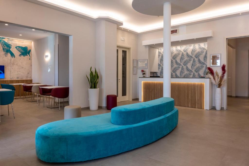 - un hall avec un canapé bleu et une table dans l'établissement Hotel Biagi & Residence, à Lido di Camaiore