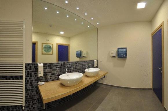 une salle de bain avec deux lavabos et un grand miroir dans l'établissement Hotel Haus Charlotte, à San Benedetto del Tronto