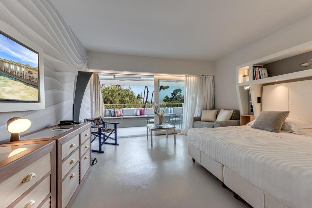 une chambre avec un grand lit et un salon dans l'établissement Augustus Hotel & Resort, à Forte dei Marmi