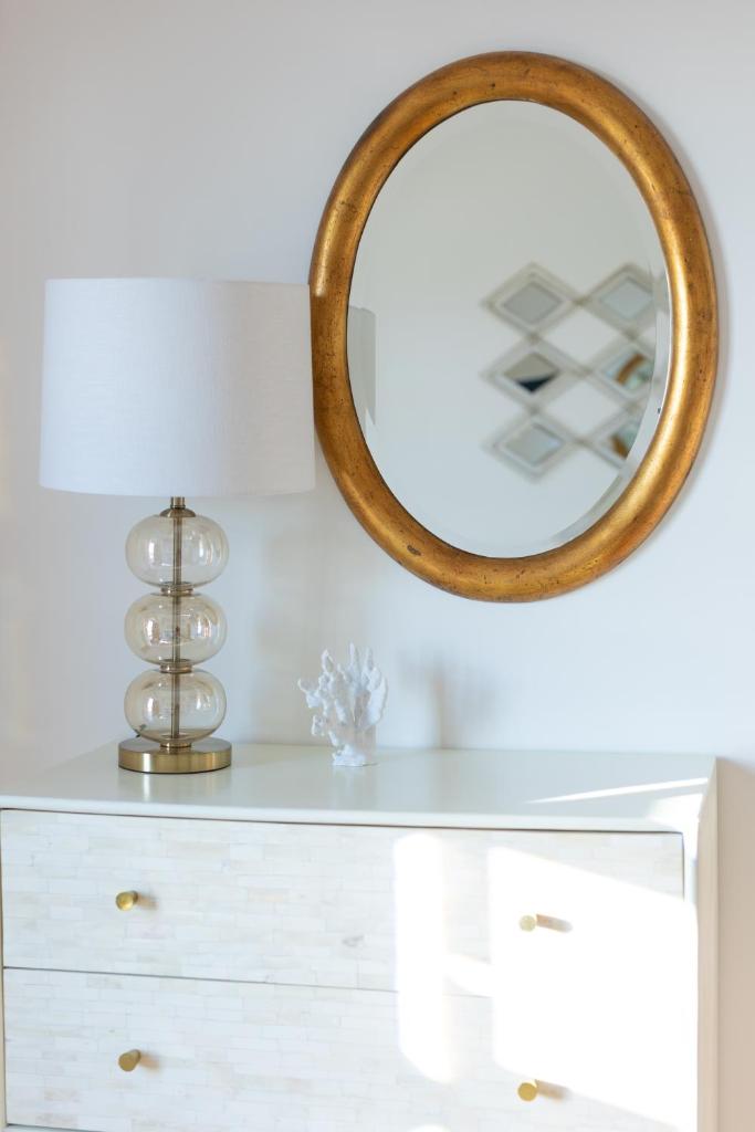 un miroir au-dessus d'une commode avec un vase dans l'établissement Villa Aurora Pool & Fitness, à Anacapri