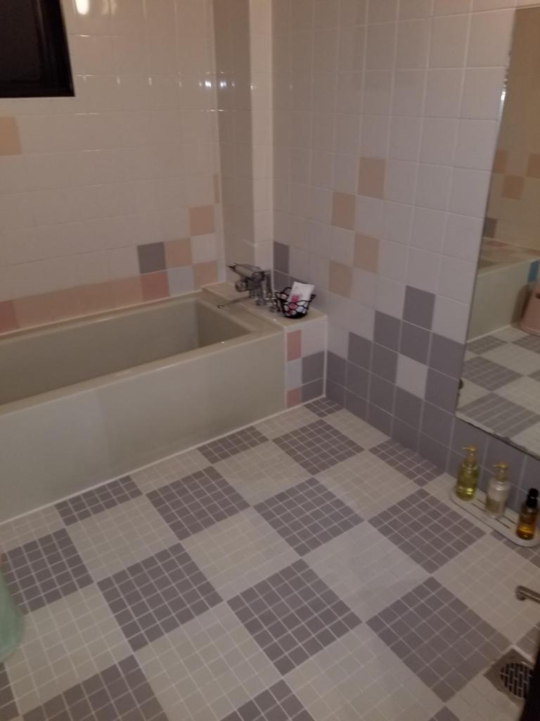 une salle de bain avec baignoire et sol carrelé dans l'établissement スタイリッシュ-大人専用, à Kameyama