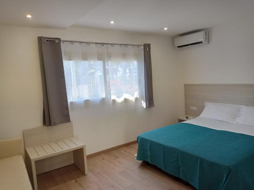 une chambre avec un lit bleu et une fenêtre dans l'établissement Tropical Suite, à Diamante