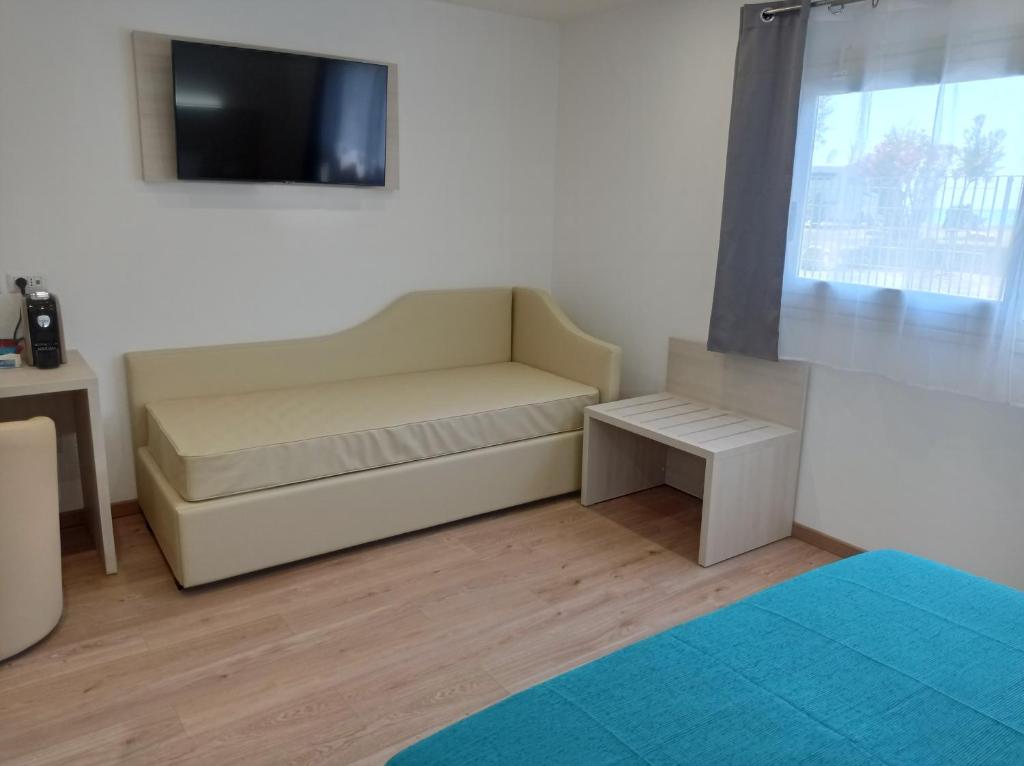 Cette chambre dispose d'un canapé et d'une télévision murale. dans l'établissement Tropical Suite, à Diamante