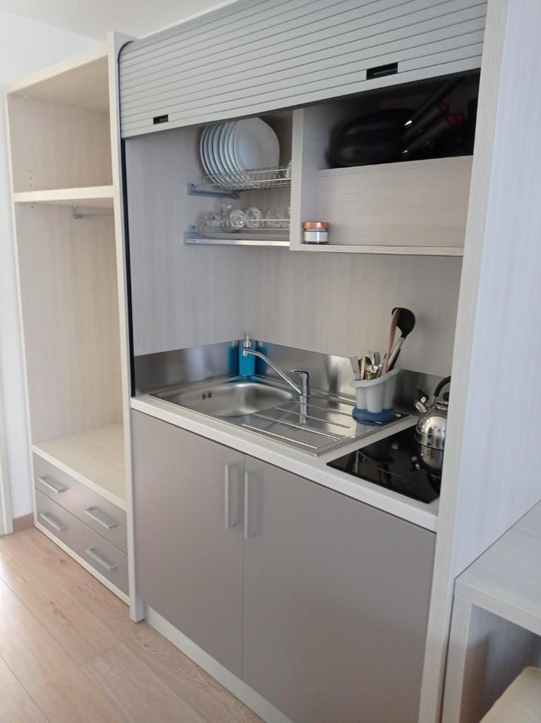 une petite cuisine avec un évier et une cuisinière dans l'établissement Tropical Suite, à Diamante