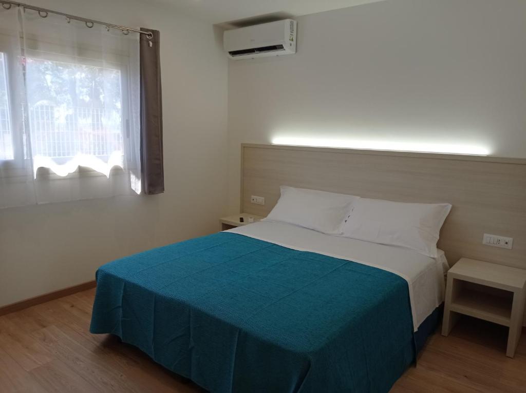 une chambre avec un lit avec une couverture bleue et une fenêtre dans l'établissement Tropical Suite, à Diamante