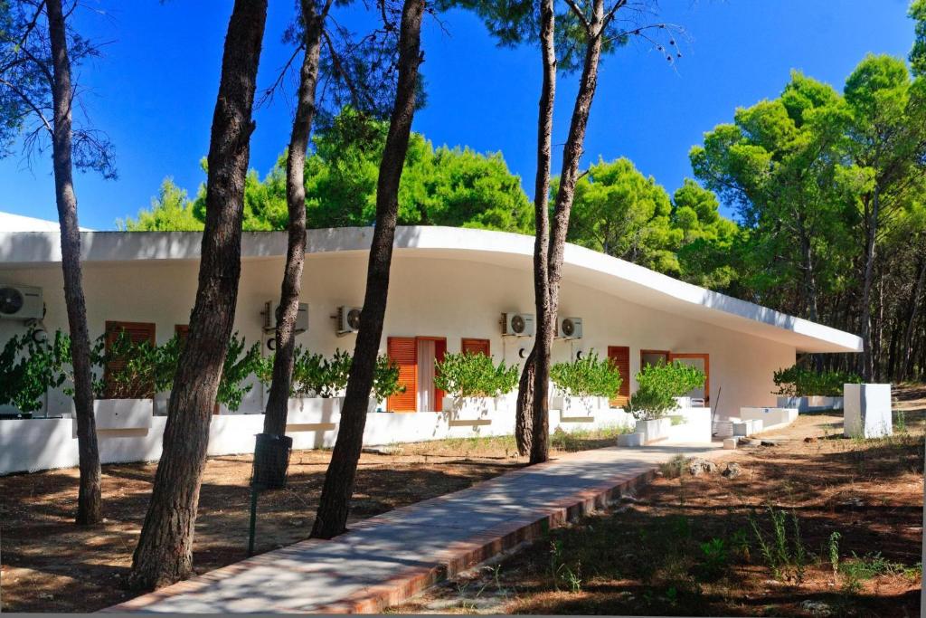 une maison avec des arbres devant elle dans l'établissement Hotel Kyrie Isole Tremiti, à San Domino