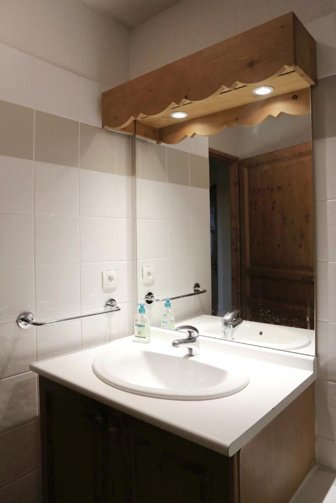 une salle de bain avec un lavabo et un miroir dans l'établissement Saint-Gervais apartment next to Bettex ski lift, à Saint-Gervais-les-Bains 9 autres photos