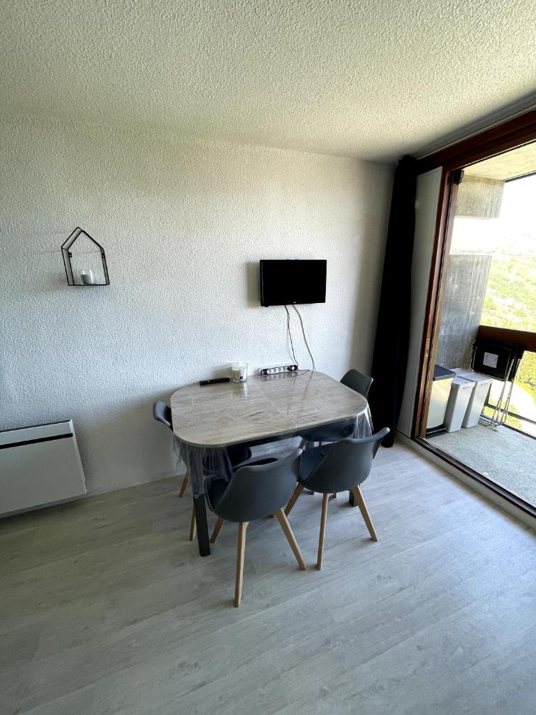une table dans une pièce avec deux chaises et une télévision dans l'établissement Studio au pied des pistes avec balcon 4/6 pers, à Villarembert