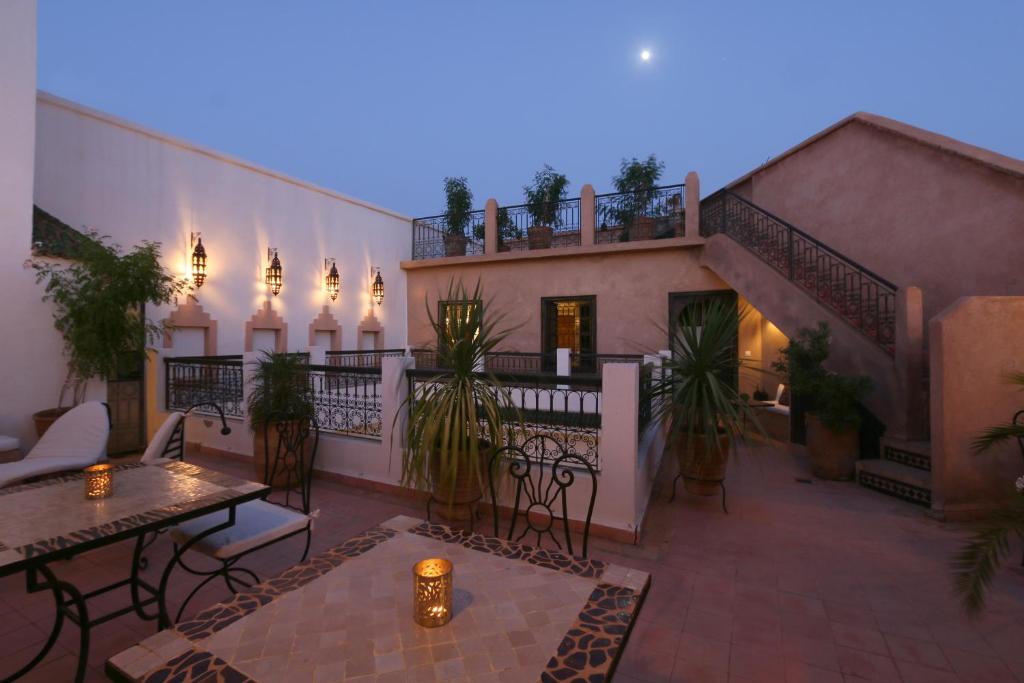 un patio extérieur avec tables et chaises et un bâtiment dans l'établissement Riad Baba Ali, à Marrakech