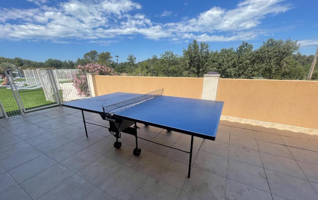 - une table de ping-pong au-dessus d'une terrasse dans l'établissement Charmant Chalet avec terrasse et accès piscine., à Rocbaron