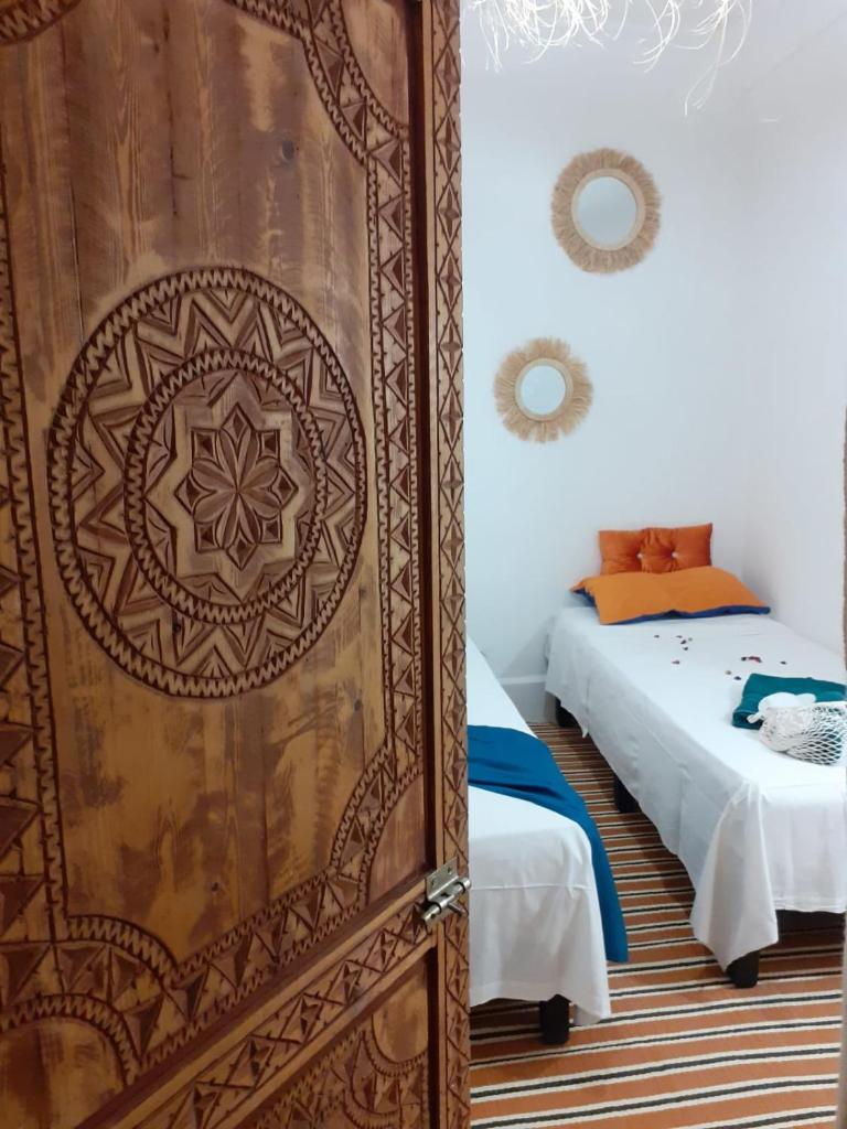 - une chambre avec une grande porte en bois et un lit dans l'établissement Riad Bouchouari 33, à Marrakech