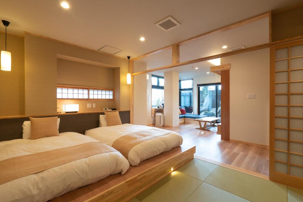 une chambre avec un grand lit dans une pièce dans l'établissement Maruyama Onsen Kojyokan, à Minami Uonuma