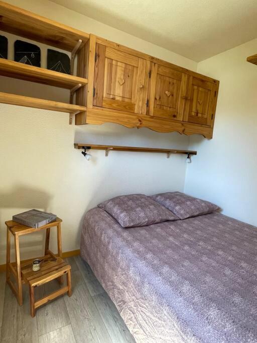 - une chambre avec un lit et des placards en bois dans l'établissement Appartement aux pieds des pistes - La Plagne Montalbert - Panorama 1350, à Aime La Plagne