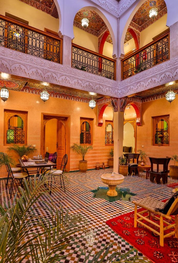 une grande salle avec des tables et des chaises ainsi qu'une fontaine dans l'établissement RIAD VILLA SIDI BABA, à Marrakech