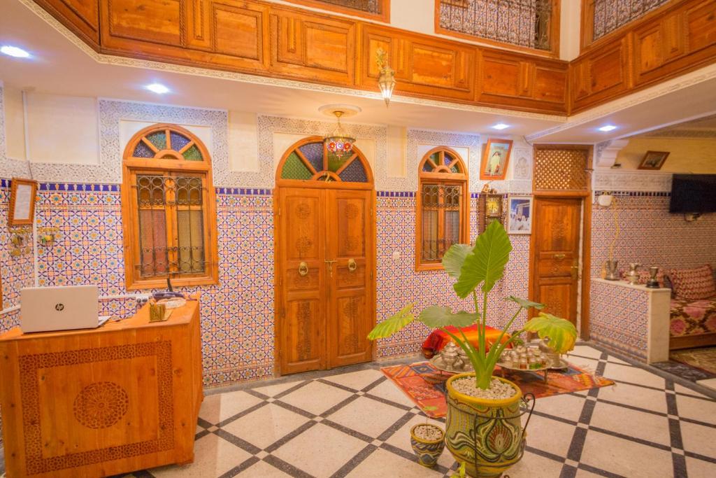 une cuisine avec des portes en bois et une plante en pot dans l'établissement Riad Haddaji Fes, à Fès