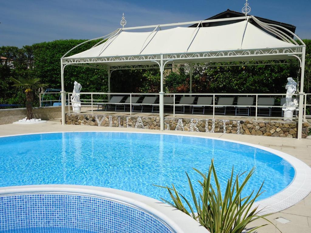 une grande piscine avec un gazebo en arrière-plan dans l'établissement VILLA GARUTI VILLAGE, à Padenghe sul Garda