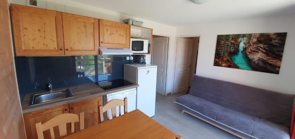 une petite cuisine avec un évier et un micro-ondes dans l'établissement Appartement 3 étoiles 6 personnes les Orres 1800, aux Orres 7 autres photos