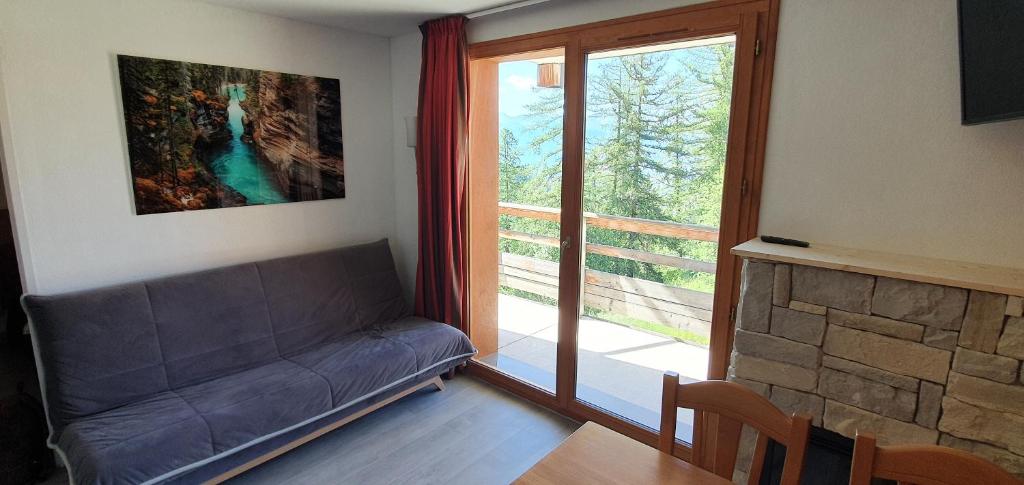 un salon avec un canapé et une grande fenêtre dans l'établissement Appartement 3 étoiles 6 personnes les Orres 1800, aux Orres