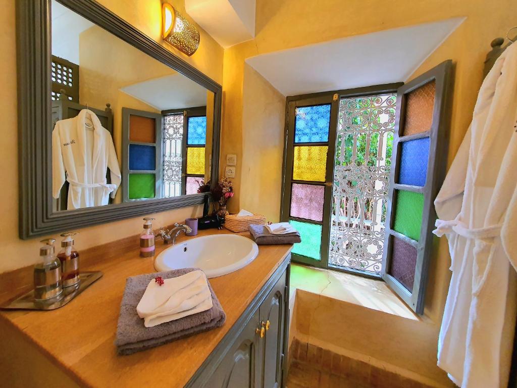 La salle de bains est pourvue d'un lavabo et de vitraux. dans l'établissement Riad Dar Zouar & Spa, à Marrakech