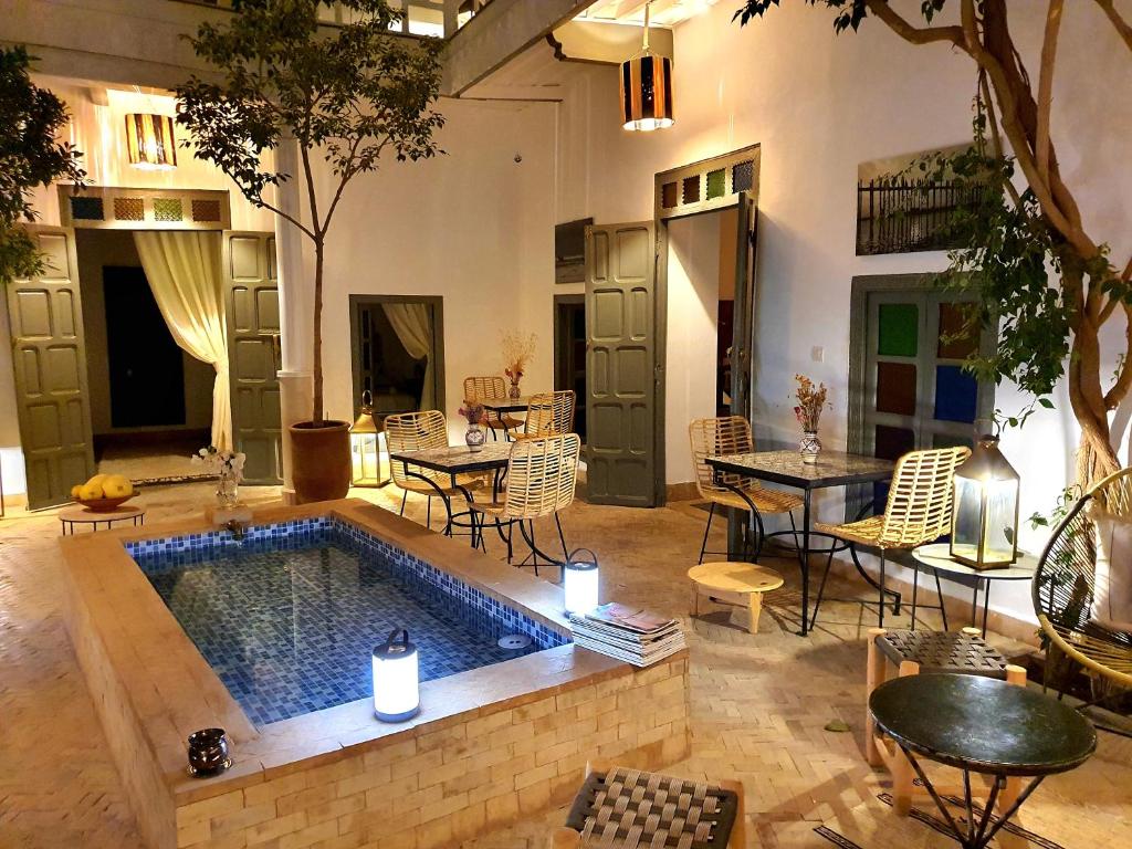 - une piscine dans une terrasse avec des tables et des chaises dans l'établissement Riad Dar Zouar & Spa, à Marrakech