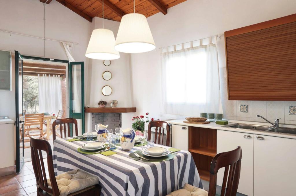 une cuisine avec une table et un tissu de table rayé dans l'établissement Villa Marzallo by Villa Plus, à Santa Maria Del Focallo