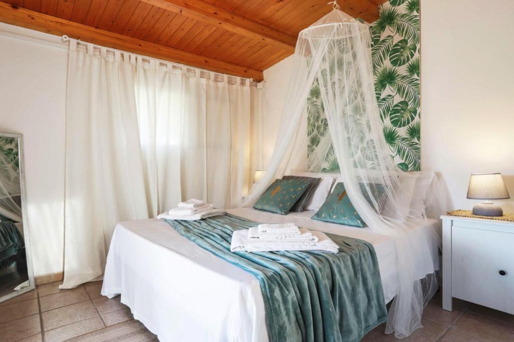 une chambre avec un lit blanc à baldaquin dans l'établissement Villa Marzallo by Villa Plus, à Santa Maria Del Focallo