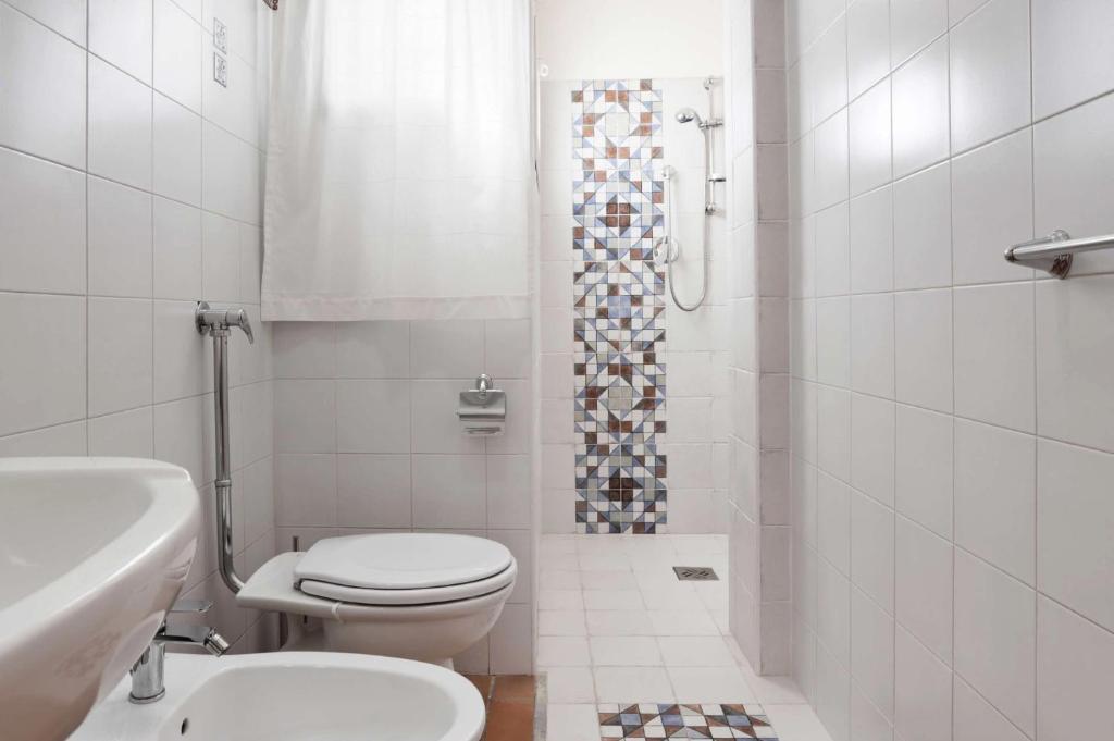une salle de bain blanche avec toilettes et douche dans l'établissement Villa Marzallo by Villa Plus, à Santa Maria Del Focallo 31 autres photos
