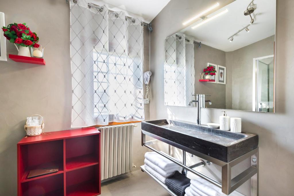 une salle de bain avec un lavabo et un grand miroir dans l'établissement Casa delle Noci country house, pool & SPA, à Modène