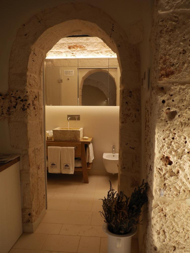 une salle de bain avec un lavabo et des toilettes dans une chambre dans l'établissement Trulli Terra Viva, à Alberobello