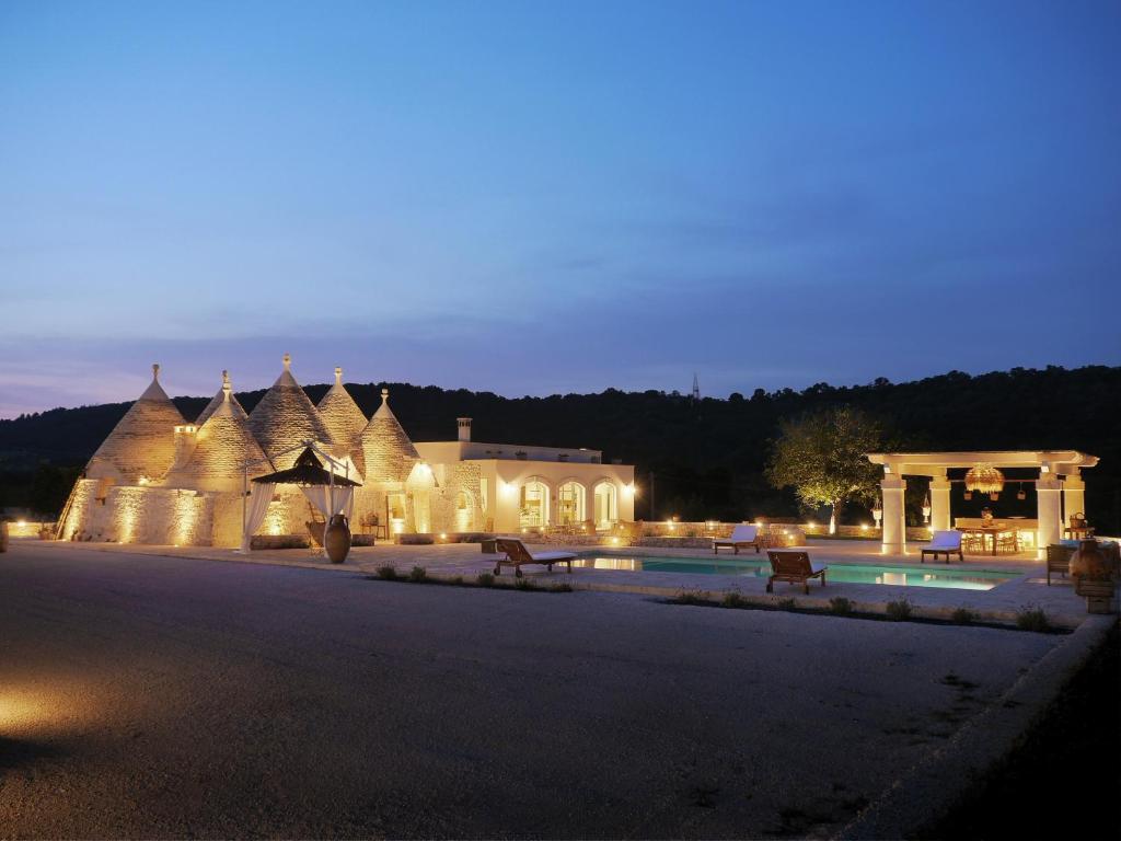 - un bâtiment avec une piscine et un kiosque la nuit dans l'établissement Trulli Terra Viva, à Alberobello