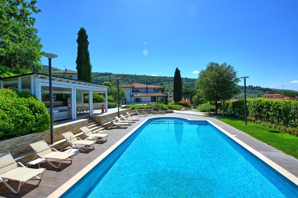 une piscine avec des chaises longues et une maison dans l'établissement Casa White by PosarelliVillas, à Castiglion Fiorentino