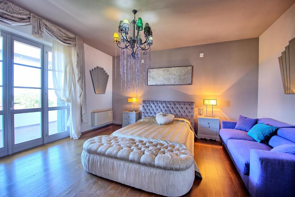 une chambre avec un grand lit et un canapé bleu dans l'établissement Casa White by PosarelliVillas, à Castiglion Fiorentino 25 autres photos