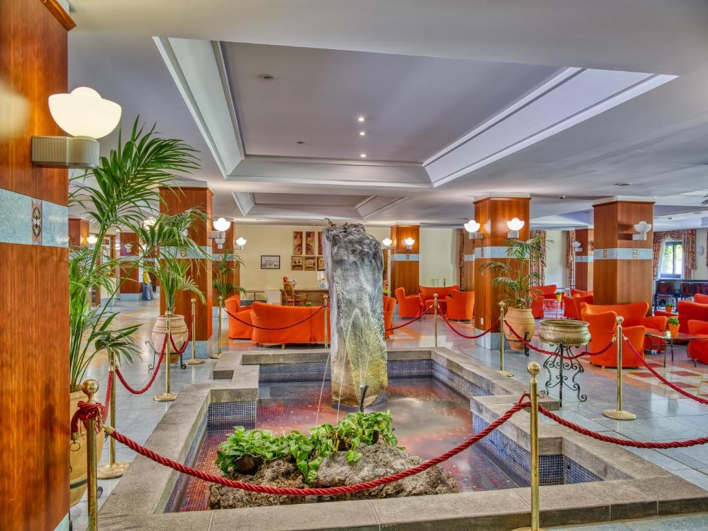 un hall d'hôtel avec une fontaine au milieu dans l'établissement Hotel Caesar Palace, à Giardini Naxos 120 autres photos