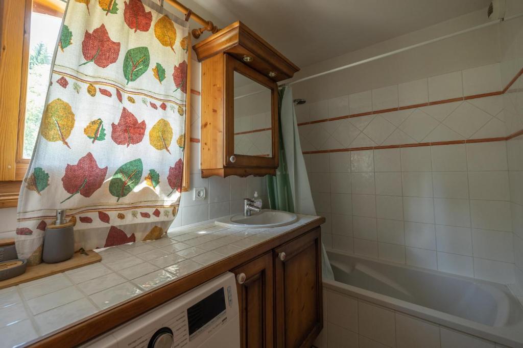 une salle de bain avec un lavabo et un rideau de douche dans l'établissement Morillon 1100 Skis aux pieds, à Morillon