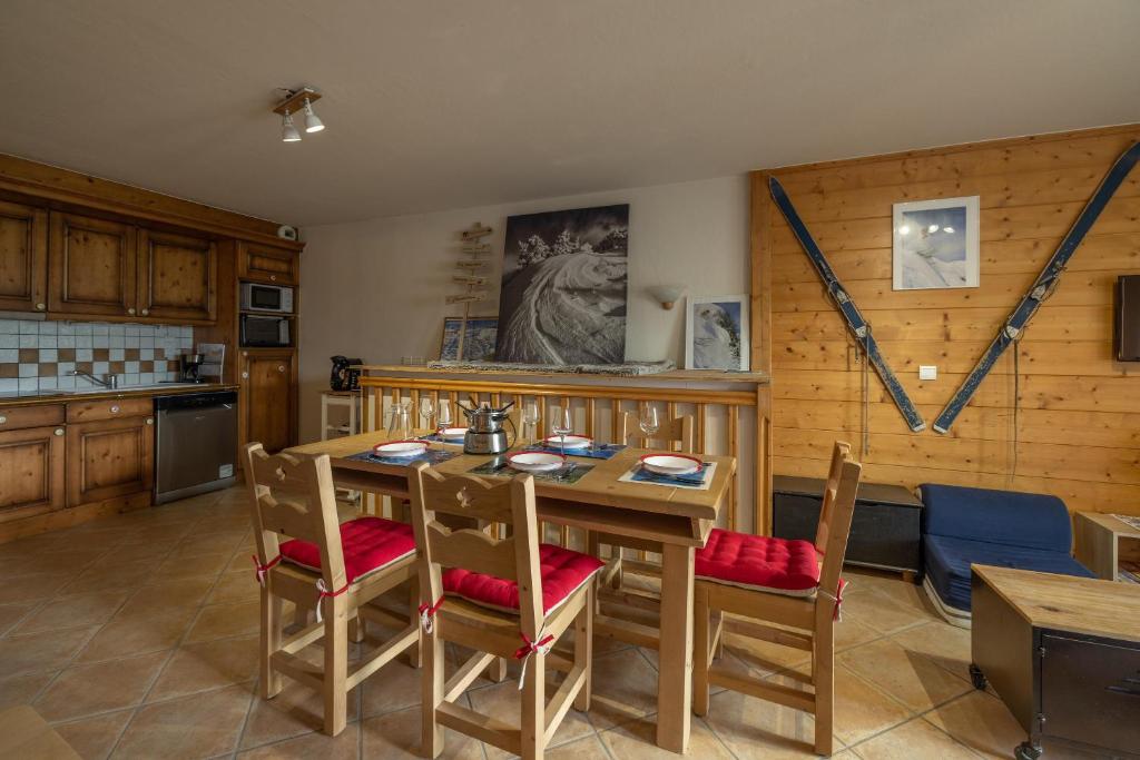 une cuisine avec une table et des chaises en bois dans l'établissement Morillon 1100 Skis aux pieds, à Morillon