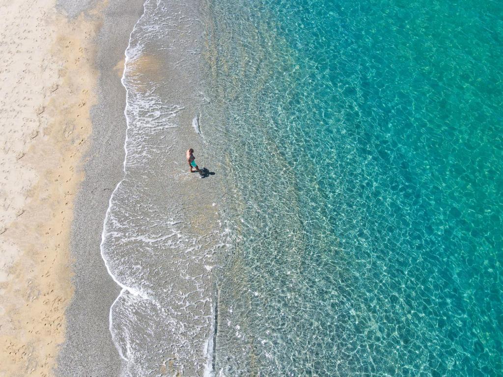 une personne debout dans l'eau sur une plage dans l'établissement Futura Club La Praya, à Pizzo
