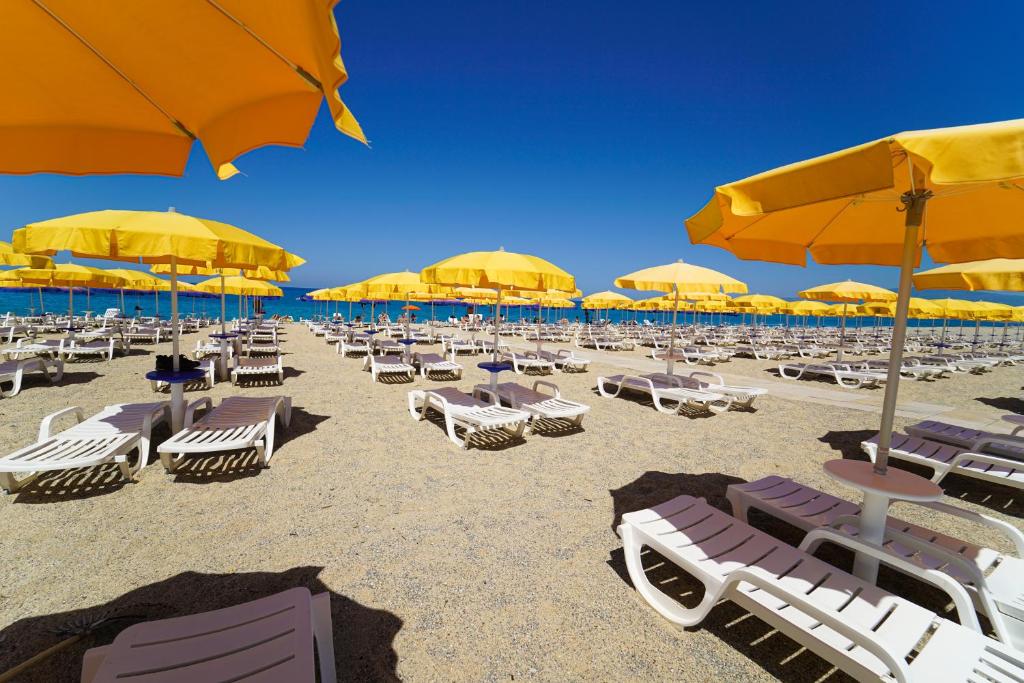 - un bouquet de chaises et de parasols sur une plage dans l'établissement Futura Club La Praya, à Pizzo