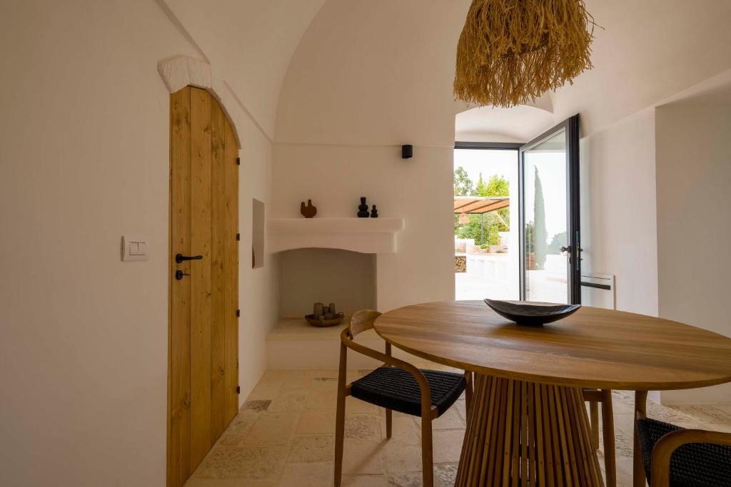 une salle à manger avec une table et des chaises en bois dans l'établissement Trulli Petramyrta, à Ceglie Messapica