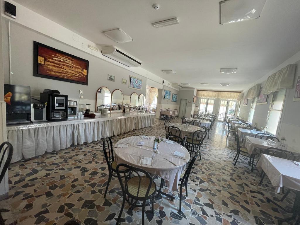 un restaurant avec des tables et des chaises dans une salle dans l'établissement Hotel moroni, à Rimini