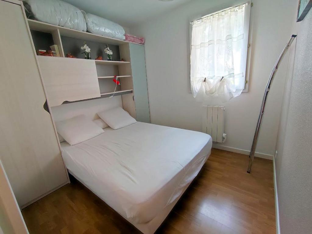 une petite chambre avec un lit et une fenêtre dans l'établissement Au doux refuge, charmant T2 bis, parking gratuit, proche thermes, 6 personnes, à Luchon