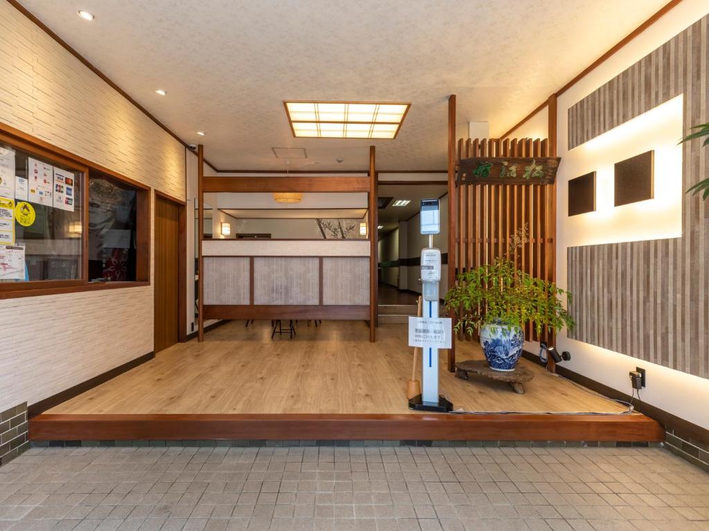 un couloir d'un immeuble avec un vase au sol dans l'établissement Tabist Matsuekan, à Matsue